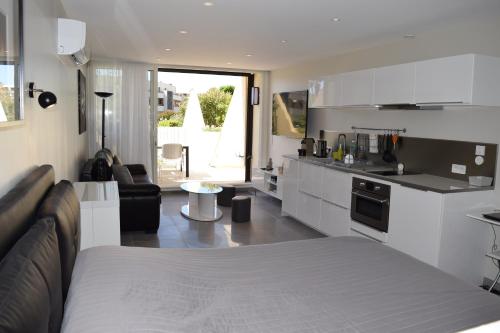 - une cuisine et un salon avec un lit dans une chambre dans l'établissement HELIOPOLIS CAP D'AGDE VILLAGE NATURISTE, au Cap d'Agde