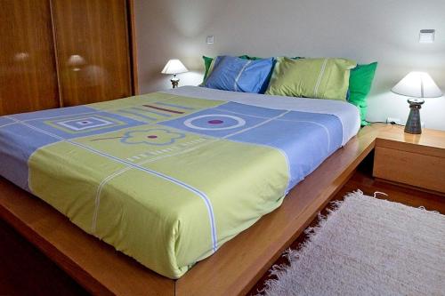 una cama grande con una pintura en un dormitorio en Apartment Labruge, en Praia de Angeiras