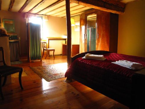 une chambre avec un lit et une chaise dans une pièce dans l'établissement Belrepayre, à Manses