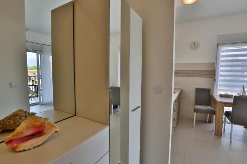 a kitchen with a cabinet and a table in a room at Kristina Apartments in Tivat