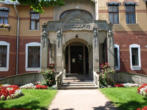 a red brick building with a door and flowers at Villa Ammende Restaurant and Hotel in Pärnu