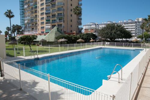 a large blue swimming pool in a city at Apart EAM Maite 3 in Benalmádena