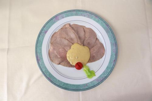 a plate with a piece of meat and a sauce at La rosa dei vini in Serralunga d'Alba