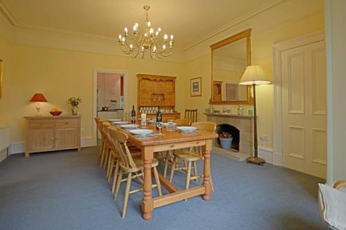 ein Esszimmer mit einem Holztisch und Stühlen in der Unterkunft Netherwood House in Newtonmore