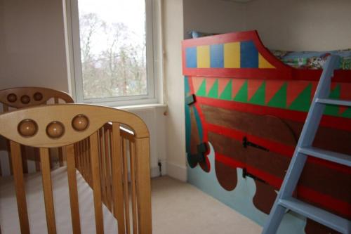 a bedroom with a bunk bed and a wooden chair at Netherwood House in Newtonmore