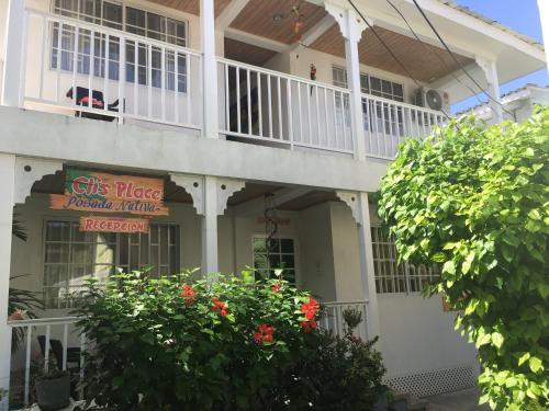 a white house with a balcony and a sign at Cli´s Place Posada Nativa in San Andrés