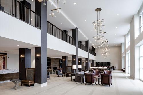 a lobby of a hotel with chairs and tables at Hotel Madison & Shenandoah Conference Ctr. in Harrisonburg