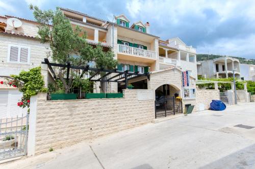 an apartment building with a gate and a courtyard at Apartments and Room Napoli in Bol