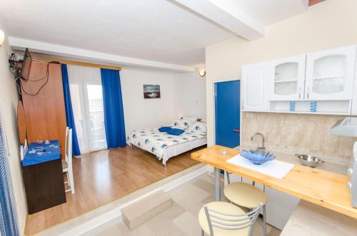 a small room with a bed and a table and chairs at Apartments and Room Napoli in Bol