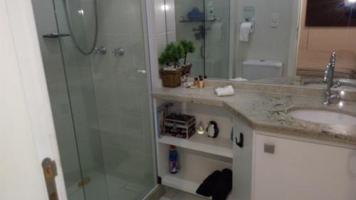 uma casa de banho com um chuveiro e um lavatório. em Apartamento em Cabo Frio em Cabo Frio