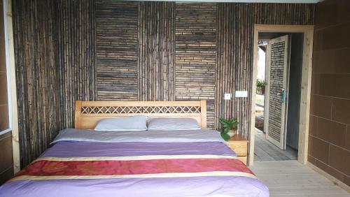 a bedroom with a large bed with a wooden headboard at Green Hostel & Sunny Guesthouse in Yuanyang