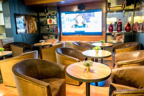 a restaurant with tables and chairs and a television at Hotel CityFlats in Bogotá