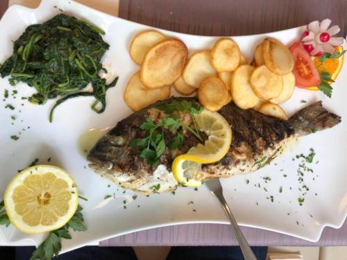 a plate with a fish and chips and vegetables at Hotel Friedrich in Hachenburg