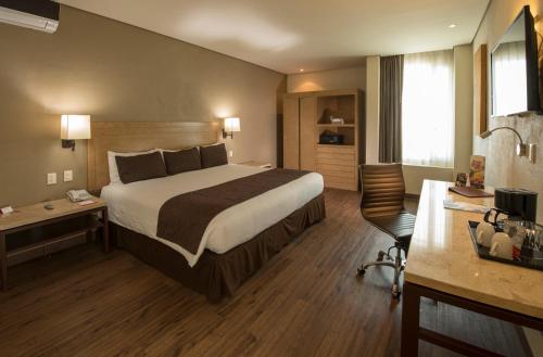 a hotel room with a bed and a desk at Victoria Ejecutivo in Guadalajara
