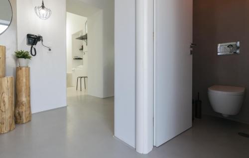 a bathroom with white walls and a toilet at Uncle's Luxury Jacuzzi in Adamas