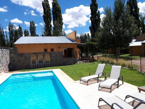 a villa with a swimming pool and a house at Cabañas Monte Coiron in Malargüe