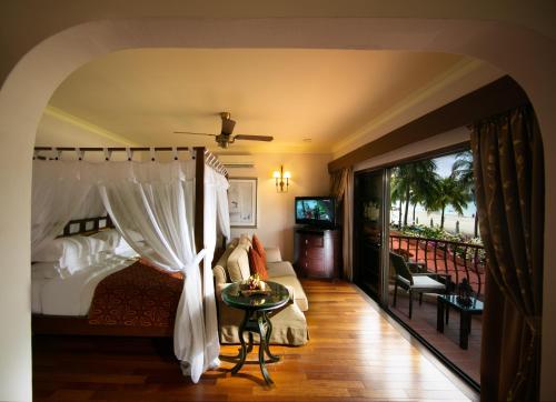 ein Schlafzimmer mit einem Bett und einem Balkon in der Unterkunft Casa del Mar Langkawi in Pantai Cenang