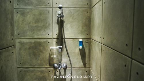 una doccia in un muro con dentro uno spazzolino di FLAT06 cipete a Giacarta