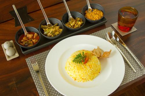 un plato de comida en una mesa con tazones de comida en Tea Plant Nuwara Eliya, en Nuwara Eliya