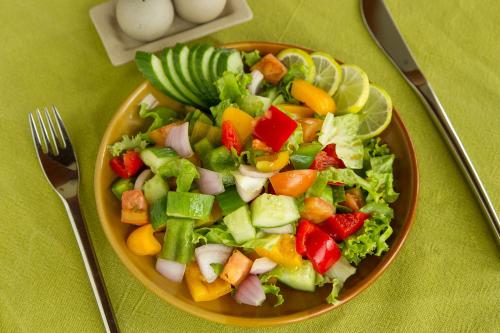 un tazón de ensalada con verduras en una mesa en Tea Plant Nuwara Eliya, en Nuwara Eliya
