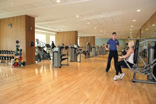 a man and a woman exercising in a gym at Khalidiya Palace Rayhaan by Rotana, Abu Dhabi in Abu Dhabi