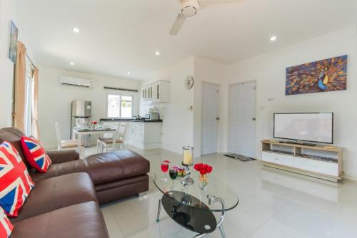 a living room with a couch and a glass table at Chalong - 2 Bedroom Hideaway Private Pool Villa - Phuket in Chalong 