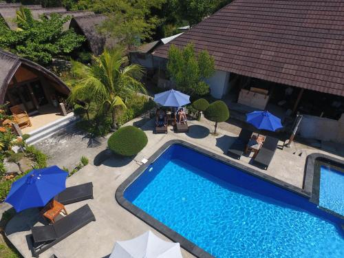 an overhead view of a swimming pool with umbrellas at Sandy Beach Bungalows in Gili Islands