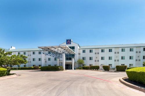 a building with a basketball hoop in front of it at Motel 6-Irving, TX - DFW Airport North in Irving