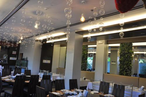 a dining room with tables and chairs and chandeliers at Hotel Lapira in Vigan