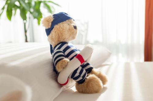 a stuffed teddy bear sitting on a couch with a bone at Dorint Strandresort & Spa Westerland/Sylt in Westerland (Sylt)