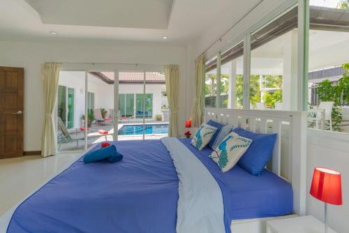 a bedroom with a large bed with blue pillows at Phikun 4 BR Private Pool Villa in Chalong 