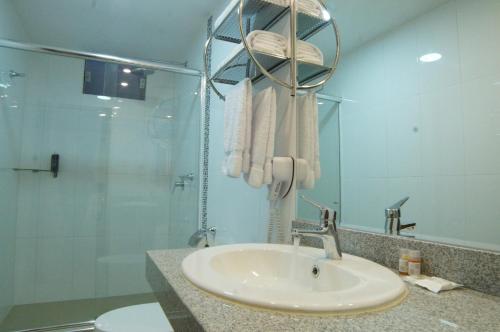 a bathroom with a sink and a shower at Águila Dorada Selva Hotel in Pucallpa