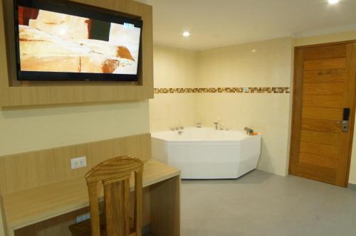 a bathroom with a sink and a tv on the wall at Águila Dorada Selva Hotel in Pucallpa