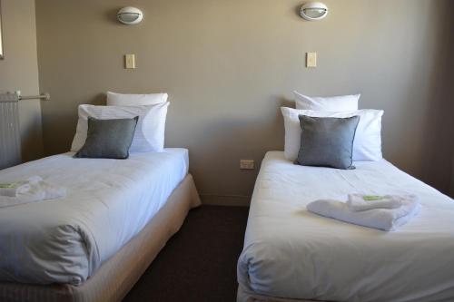 two beds sitting next to each other in a room at Commercial Hotel Motel Lithgow in Lithgow