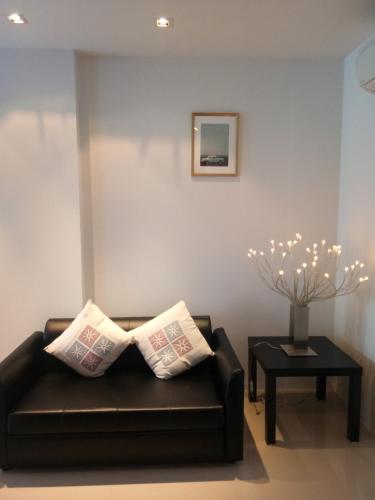 a living room with a couch and a table at Mosaic Condominium by Malai in Mae Pim