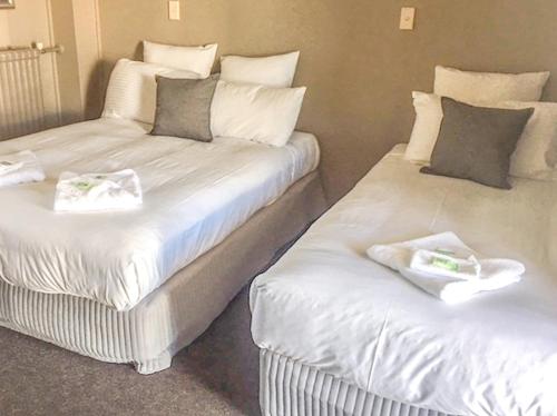 two beds sitting next to each other in a room at Commercial Hotel Motel Lithgow in Lithgow