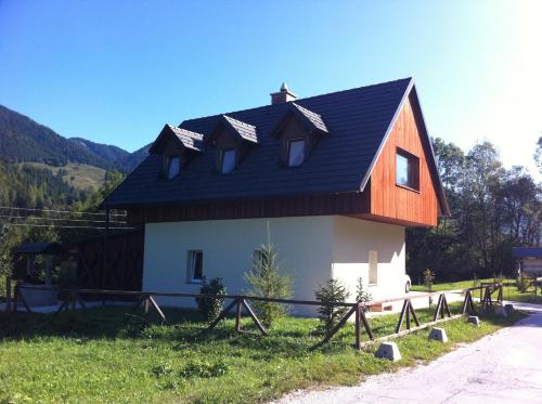 a house with a gambrel roof on top of it at Apartments Podkoren 82 in Kranjska Gora