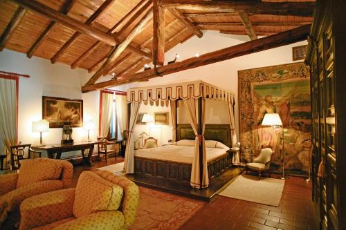 a bedroom with a canopy bed and two chairs at Locanda San Vigilio in Garda