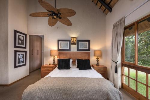 a bedroom with a bed and a ceiling fan at Kruger Park Lodge Unit No. 277 in Hazyview