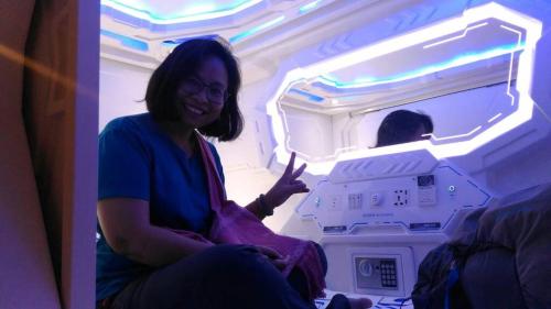 a woman sitting in front of an open refrigerator at Space Cap Hotel in Kota Kinabalu