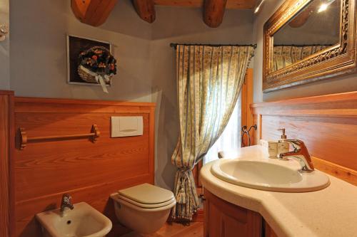 a bathroom with a white sink and a toilet at L’Invólt Mountain Lodge in Borno