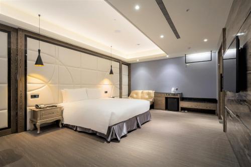 a bedroom with a large white bed and a television at Sun Hao Hotel Taichung in Taichung