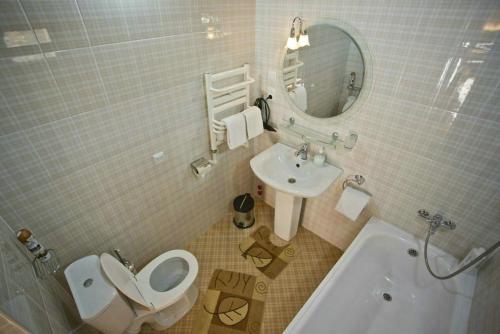 a bathroom with a toilet and a sink and a mirror at Amulet Hotel in Bukhara