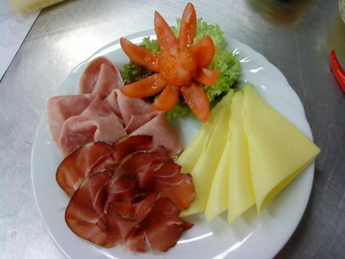 a plate of food with meat cheese and vegetables at Hotel am Rosengarten in Bad Wimpfen