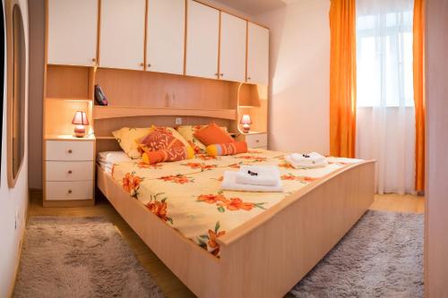 a bedroom with a large bed with orange pillows at De Luxe Apartment Mediteran 3**** in Dubrovnik