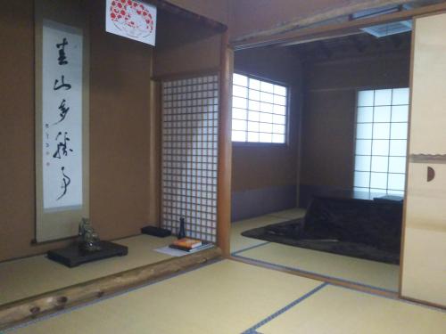 a room with a room with two windows and a mirror at Koyasan Shukubo Sainanin in Koyasan