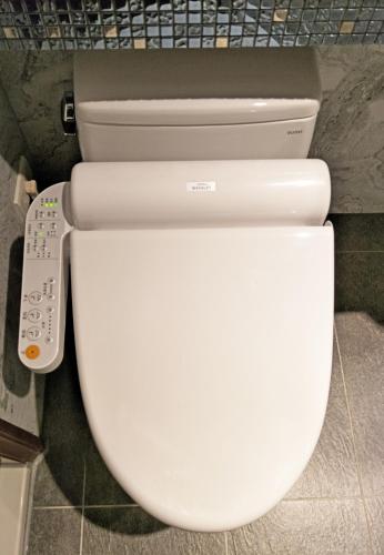 a white toilet in a bathroom with a remote control at Ueno Hirokoji 428 in Taipei