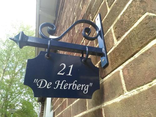a sign on the side of a brick building at De Herberg in Elim