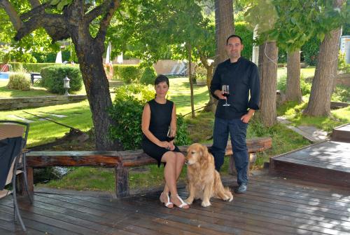 a man and a woman sitting on a bench with a dog at Molino de Alcuneza Relais & Châteaux in Sigüenza