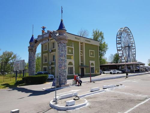 a large building with an arch and a ferris wheel at Coralia Luna Park Apartments in Mamaia